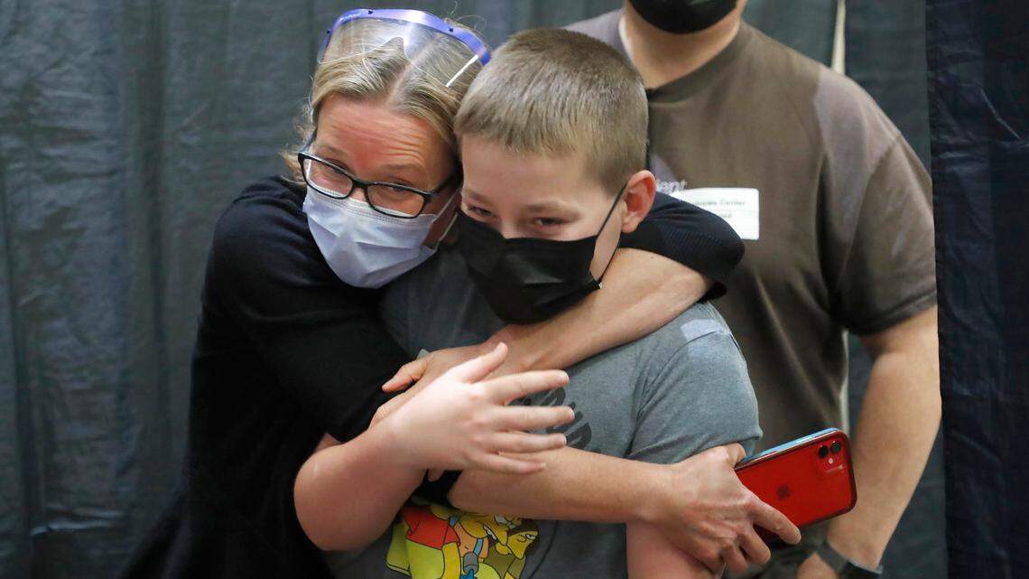 Laura Parrish hugs her son, Nathan, 12, after he received his first COVID-19 vaccine shot at WakeMed Raleigh Campus Thursday, May 13, 2021. Thursday was the first day that the Pfizer vaccine was being offered to children age 12 to 15 after the CDC approved of use on Wednesday.