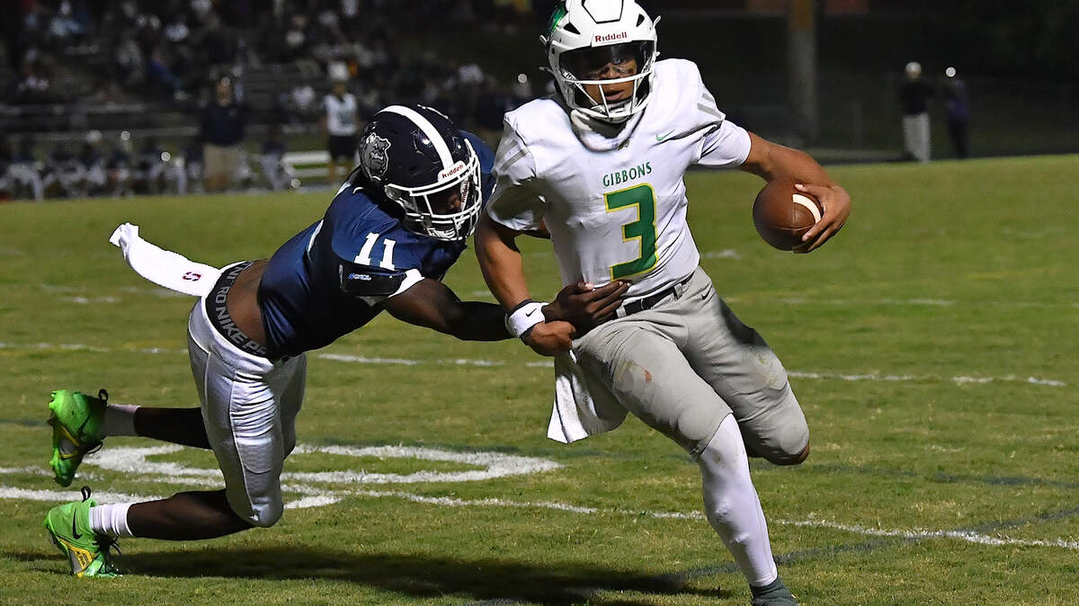 Cardinal Gibbons quarterback Gannon Jones (3) runs for yardage against Southeast Raleigh's Keysaun Eleazer (11). The Southeast Raleigh Bulldogs and the Cardinal Gibbons Crusaders met in a non-conference football game in Raleigh, N.C. September 12, 2025