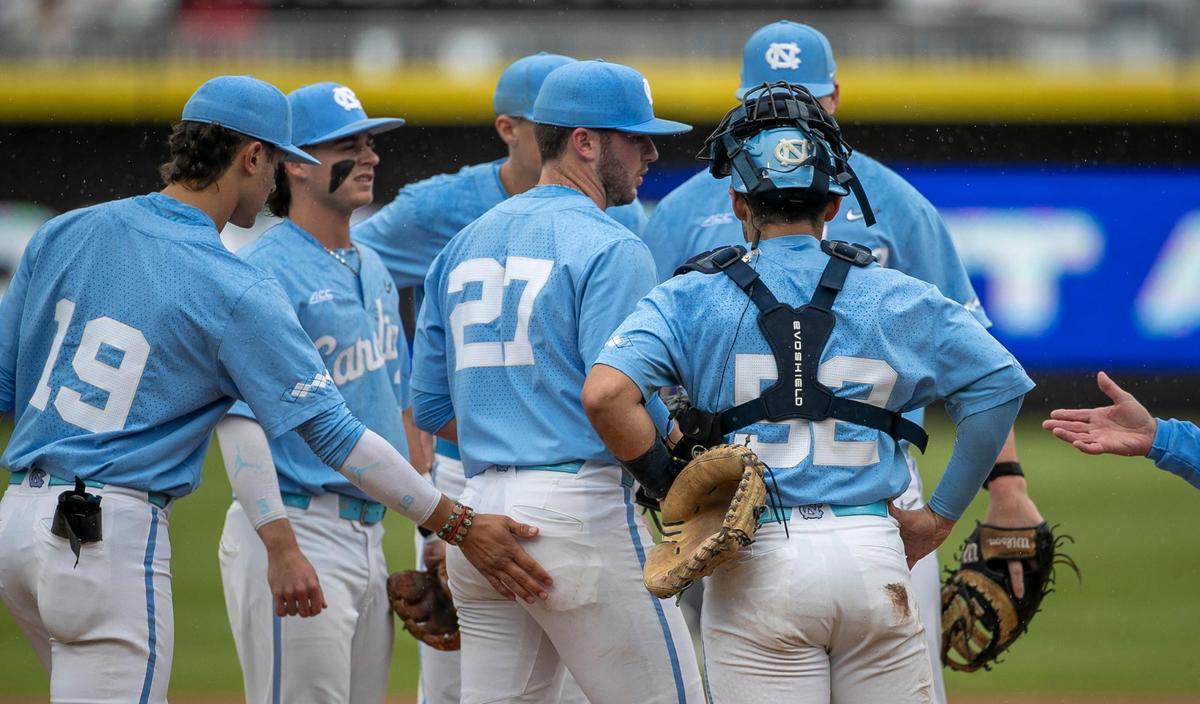 North Carolina starting pitcher Connor Bovair (27) gets a pat on the back from Johnny Castagnozzi (19) as coach Scott Forbes reaches for the ball, removing Bovair from the mound, after giving up five runs on five hits in the first inning against Clemson in the semi-finals of the 2023 ACC Baseball Championship on Saturday, May 27, 2023 at Durham Bulls Athletic Park in Durham, N.C.