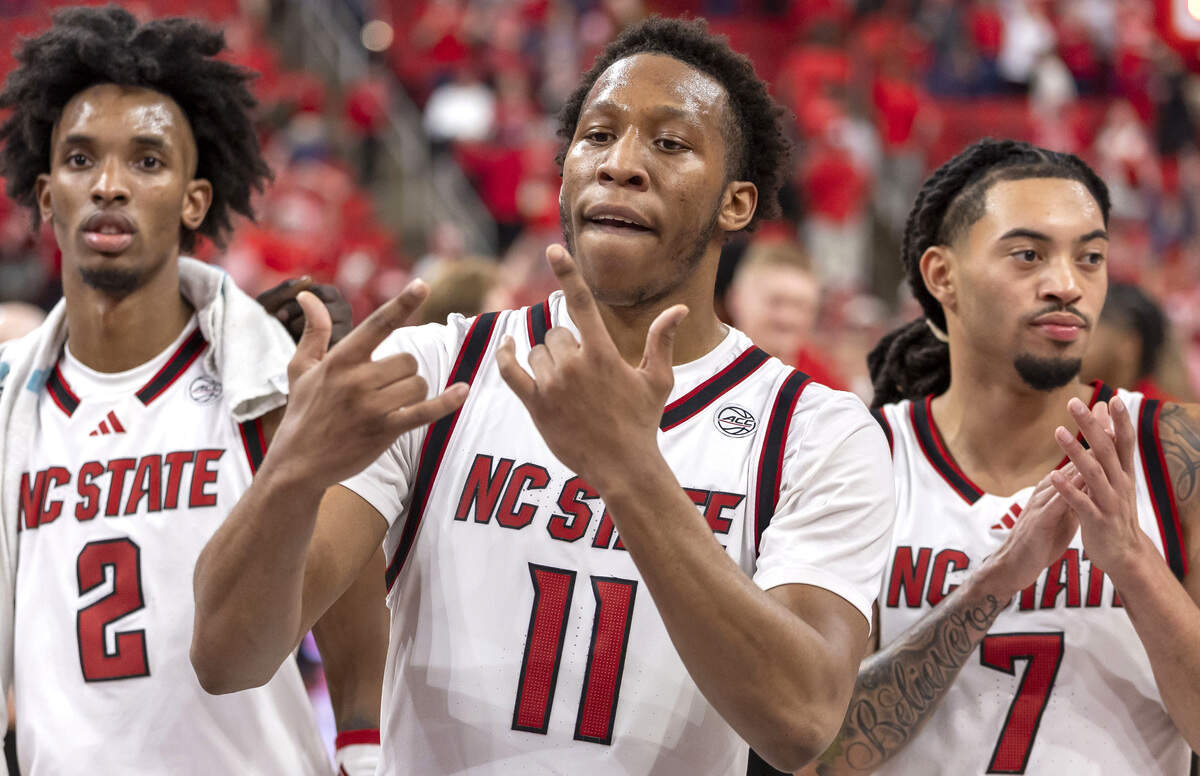 N.C. State’s Quadir Copeland (11) celebrates the Wolfpack’s 82-58 victory over North Carolina with teammates Paul McNeil Jr. (2) and Alyn Breed (7), after singing the Alma Mater on Tuesday, February 17, 2026 at Lenovo Center in Raleigh, N.C. Copeland lead all scores with 20 points.