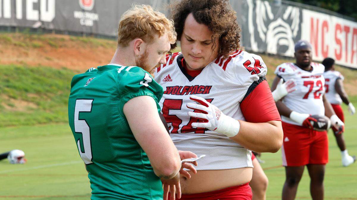 N.C. State quarterback Brennan Armstrong (5) talks with offensive lineman Dylan McMahon (54) during the Wolfpack’s first fall practice in Raleigh, N.C., Wednesday, August 2, 2023.
