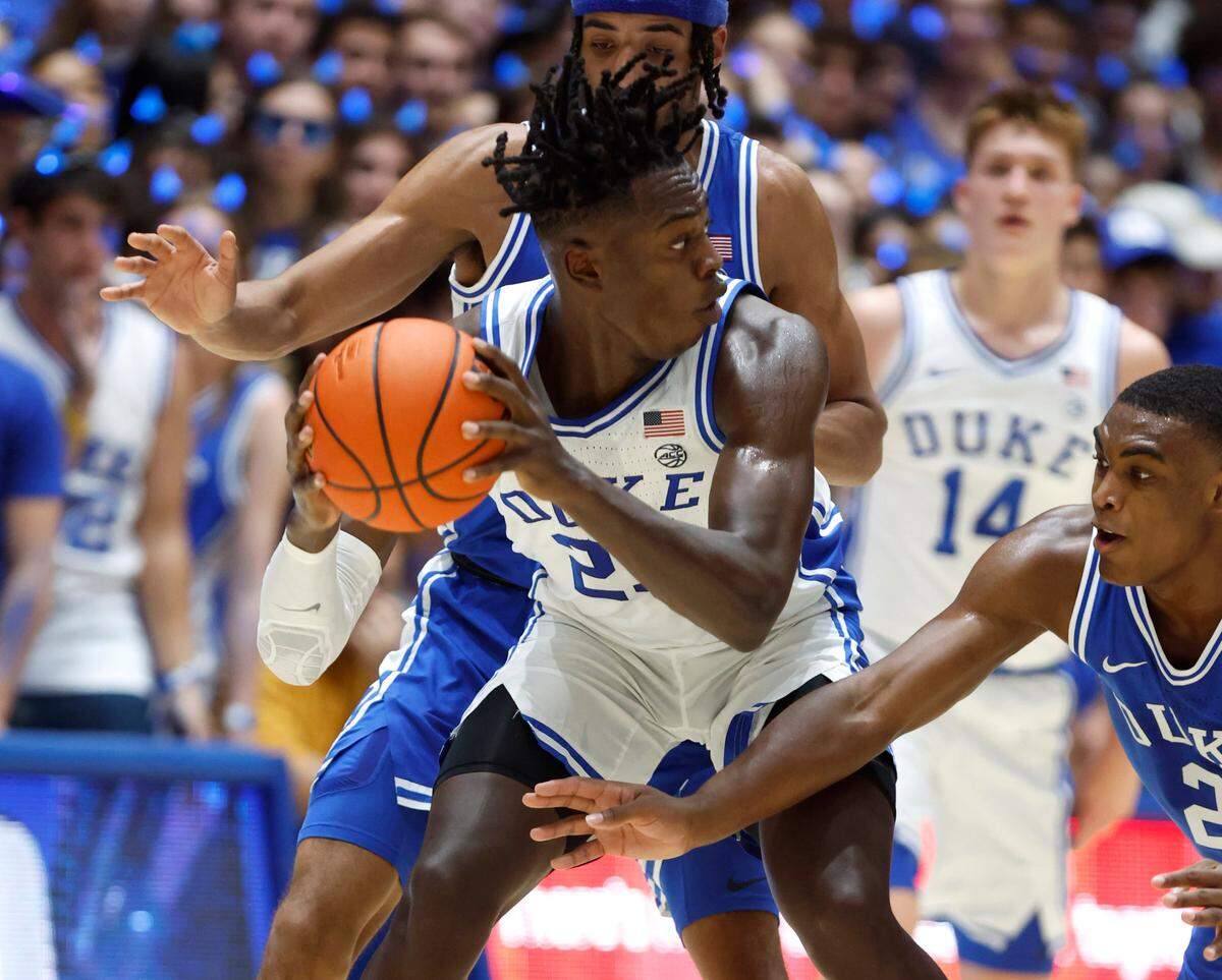 Duke’s Mark Mitchell (25) keeps the ball from Jacob Grandison (13) and Jaylen Blakes (2) during the Blue-White scrimmage during Duke’s Countdown to Craziness at Cameron Indoor Stadium in Durham, N.C., Friday, Oct. 21, 2022.