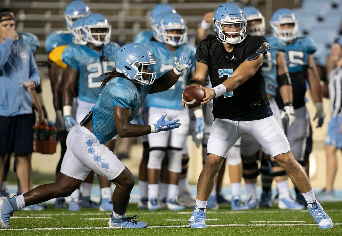 North Carolina running back Michael Carter (8) takes a hand off from quarterback Sam Howell (7) during the Tar Heels’ practice in Kenan Stadium on Monday August 19, 2019 in Chapel Hill, N.C.