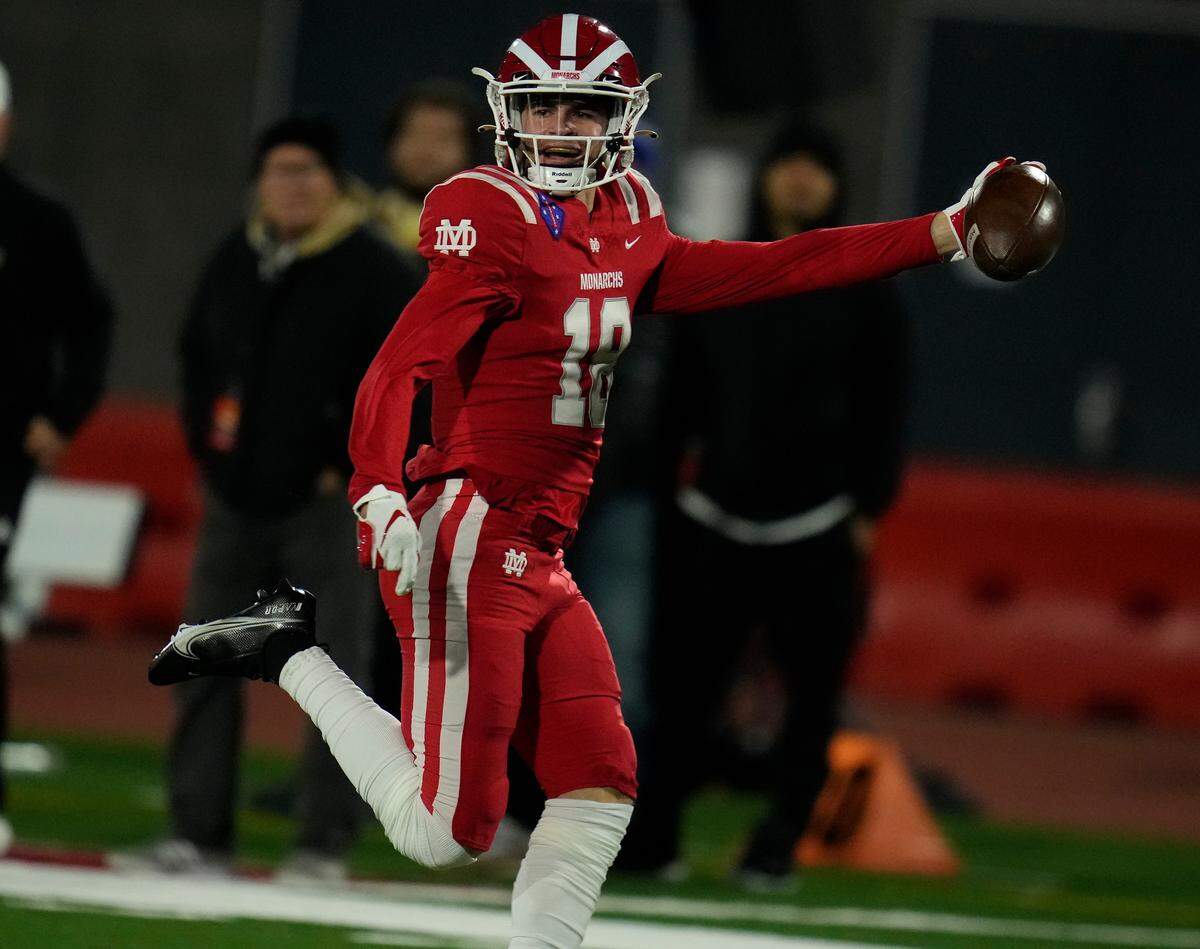 Dec 11, 2021; Mission Viejo, California, USA; Santa Ana Mater Dei Monarchs Cooper Barkate wide receiver (18) sprints to the end zone on a 74-yard pass play in the first quarter against the San Mateo Serra Padres in the 2021 CIF State Football Open Division Championship Bowl Game at Saddleback College.