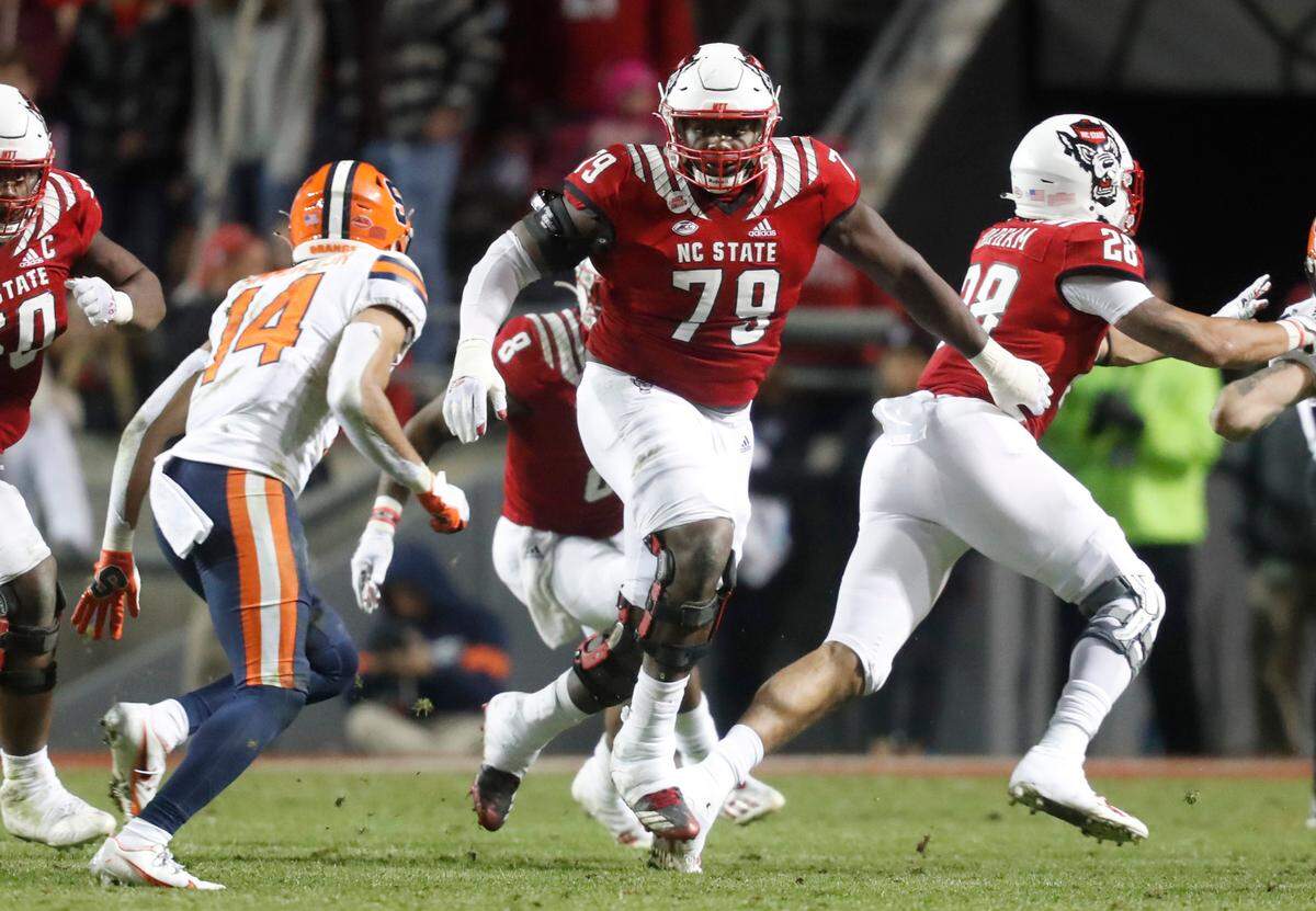 N.C. State offensive tackle Ikem Ekwonu (79) heads to block Syracuse defensive back Jason Simmons (14) during the Wolfpack’s 41-17 victory over Syracuse at Carter-Finley Stadium in Raleigh, N.C., Saturday, Nov. 20, 2021.