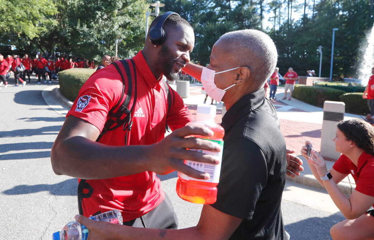N.C. State’s Tyler Baker-Williams hugs his mother Jonnita Baker-Williams during the Walk of Champions before the Wolfpack’s game against South Florida at Carter-Finley Stadium in Raleigh, N.C., Thursday, Sept. 2, 2021.