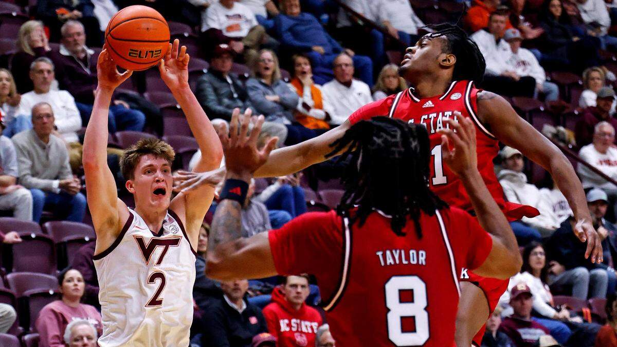 Virginia Tech Hokies guard Jaden Schutt (2) passes the ball against North Carolina State Wolfpack guard Dennis Parker Jr. (11) and \n832\ during the first half at Cassell Coliseum.