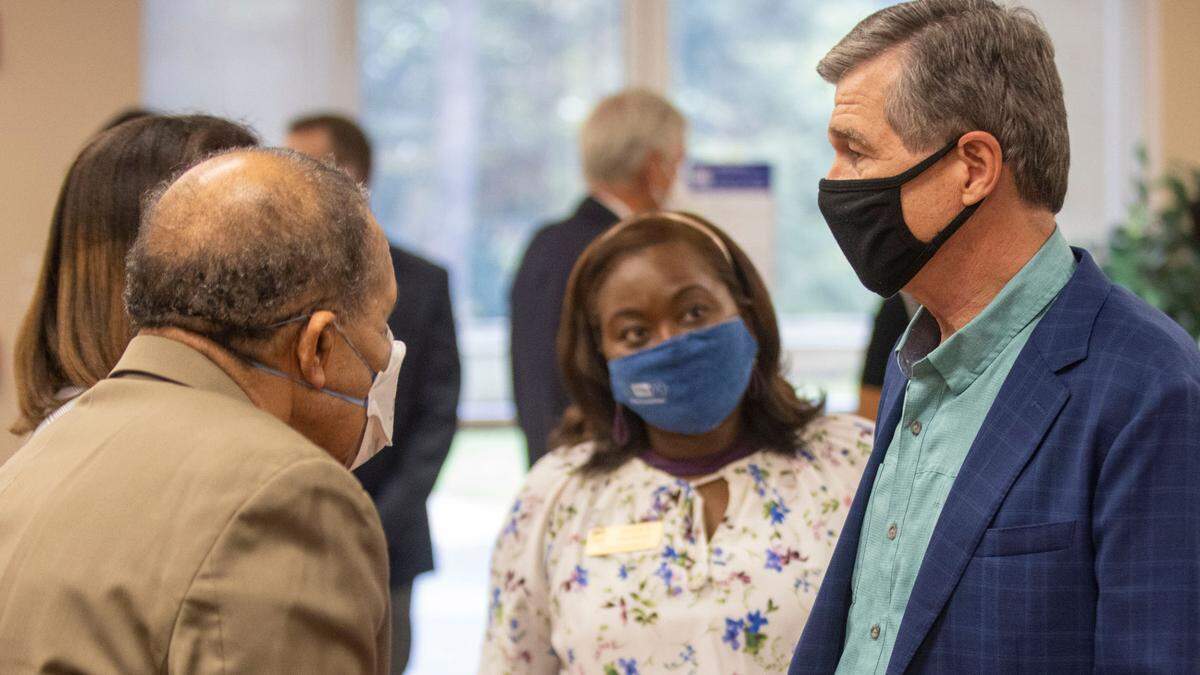Governor Roy Cooper talks with Wake County Commissioners James West and Shinica Thomas following a press briefing on COVID-19 on Thursday, September 29, 2021 at Health Park Pharmacy in Raleigh, N.C.