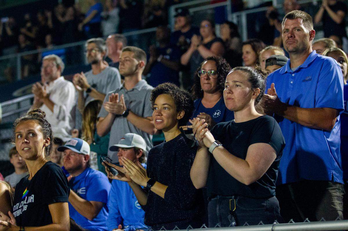 Fans stand and applaud as North Carolina Courage and Racing Louisville players form a circle and force a sixth-minute stoppage to show solidarity and protest alleged sexual abuse in the NWSL Wednesday, Oct. 6, 2021 at WakeMed Soccer Park in Cary. The NC Courage fired coach Paul Riley Thursday after former players have come forward to accuse him of sexual coercion and the NWSL’s player’s union called for an investigation.