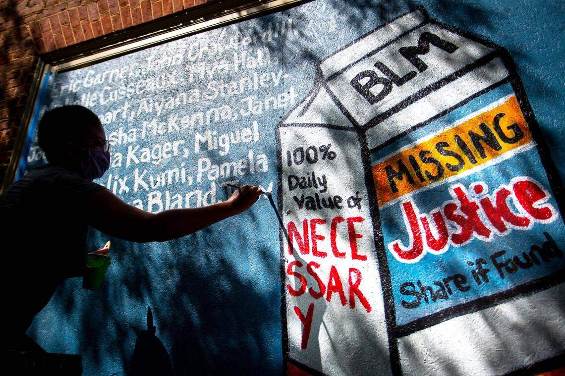Whitney Stanley works on a mural in Downtown Durham, N.C. on Sunday, June 7, 2020. Artists have come to downtown Durham to paint murals on plywood boarded-up businesses after protests against the death of George Floyd, who was killed by a Minneapolis police officer, have come to Durham and many cities across the country.