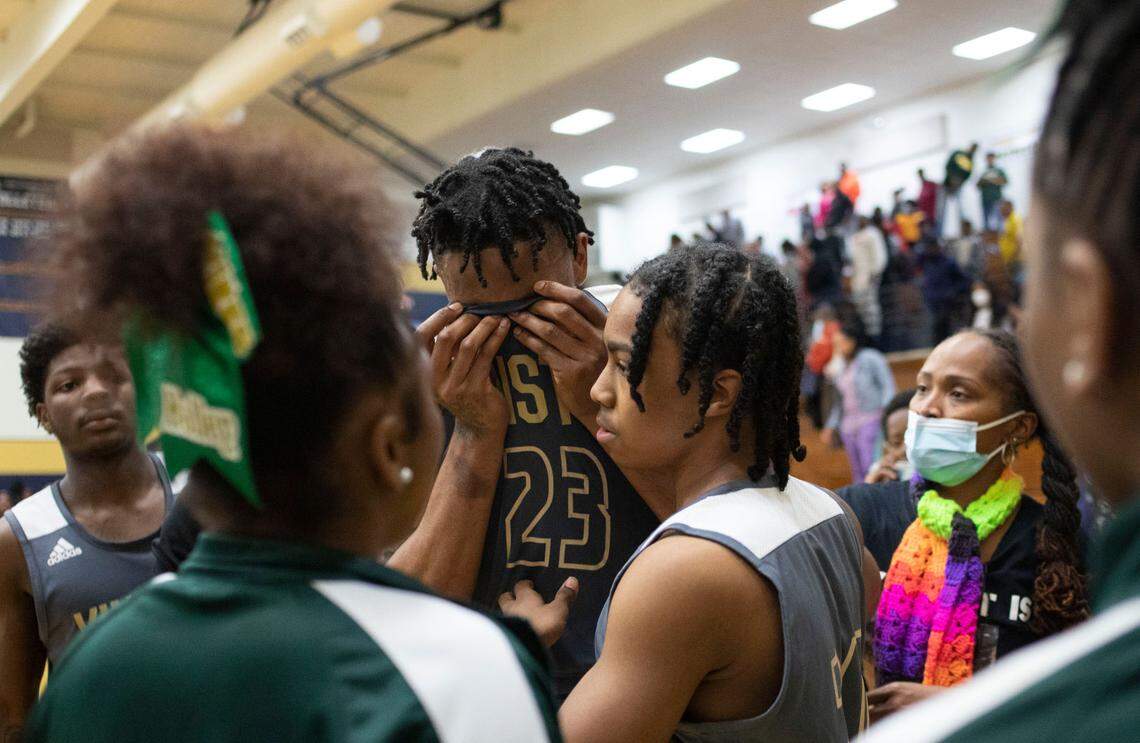 Kinston Vikings senior Jeremy Dixon (23) is comforted by friends and teammates after an emotional loss to Farmville Central during the state regional finals at Lee County High School in Sanford, N.C. on Saturday, March 5, 2022.