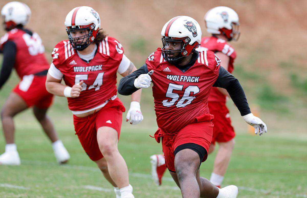N.C. State’s Lyndon Cooper (56) and Dylan McMahon (54) run a drill during the Wolfpack’s first spring practice in Raleigh, N.C., Wednesday, March 1, 2023.