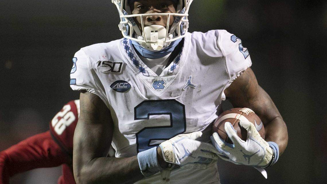 North Carolina’s Dyami Brown (2) scores on a 54-yard pass completion from quarterback Sam Howell ahead of N.C. State’s Keshawn Miller (28) to give the Tar Heels’ a 34-10 lead over N.C. State in the third quarter on Saturday, November 30, 2019 at Carter-Finley Stadium in Raleigh, N.C.