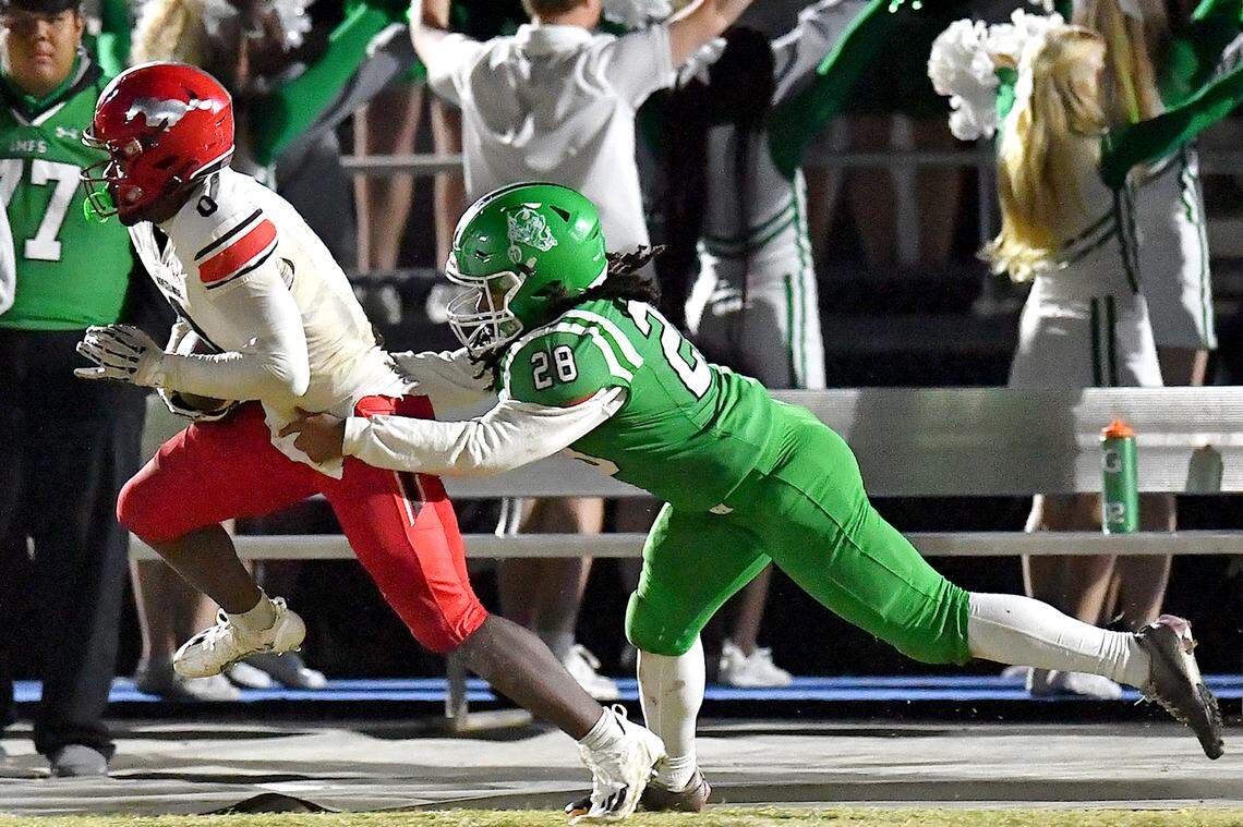 Middle Creek running back Jayden Spencer (0)  runs for the first down against Cary's Ben Hines (28) during the first half. The Cary Imps and the Middle Creek Mustangs met in a conference football game in Cary, N.C. on October 24, 2025
