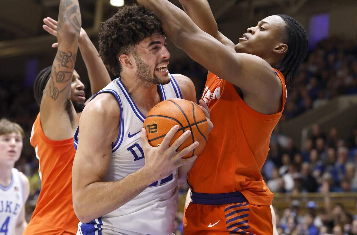 Duke’s Cameron Boozer (12) looks for room to shoot as Clemson's RJ Godfrey (0) defends during the first half of Duke’s game against Clemson at Cameron Indoor Stadium in Durham, N.C., Sat., Feb. 14, 2026.