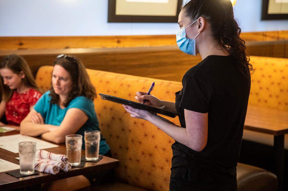 Samantha OÕNeill takes an order during a mock service to help bring staff up to speed on new safety measures to prevent against the spread of coronavirus at The Pit in Raleigh Tuesday, May 26, 2020.The Pit owner Greg Hatem says he expects to open for dine-in on Wednesday afternoon, May 27, 2020.
