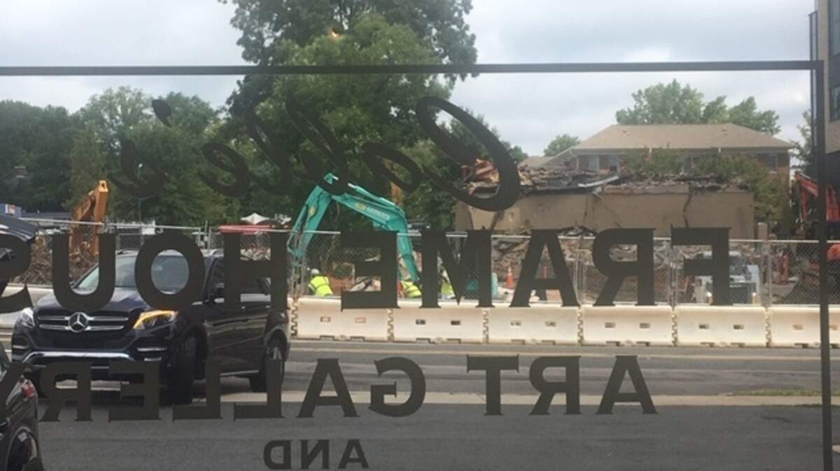 The widow of Cable’s Frame House looks out on t buildings on Raleigh’s Morgan Street being demolished to make way for a high-rise building. (News & Observer photo)