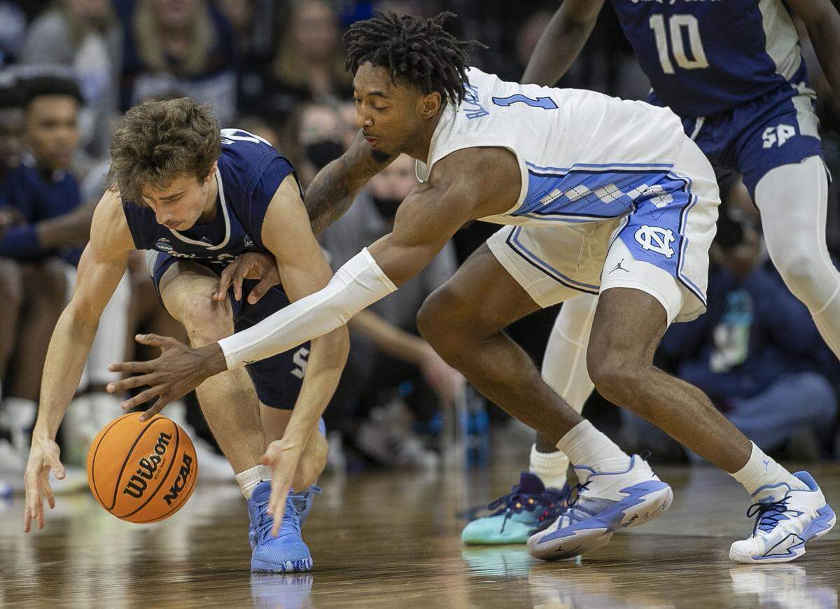 North Carolina’s Leaky Black (1) tries for a steal from Saint Peter’s Doug Edert (25) during the second half in the NCAA East Regional final on Sunday, March 27, 2022 at Wells Fargo Center in Philadelphia, Pa.