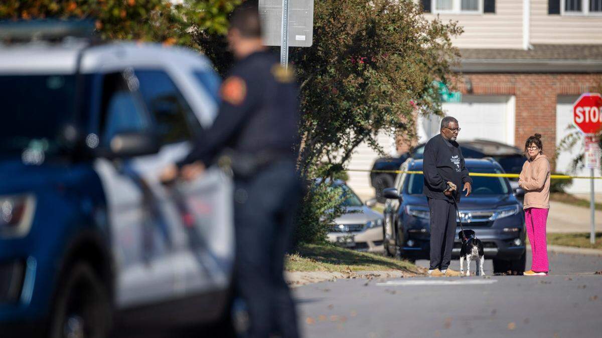 Neighbors visit with each other on Castle Pines Drive in the Hedingham neighborhood on Friday morning, October 14, 2022 in Raleigh, N.C. as law enforcement continue to investigate the shooting that killed 5 people, including an off-duty police officer.