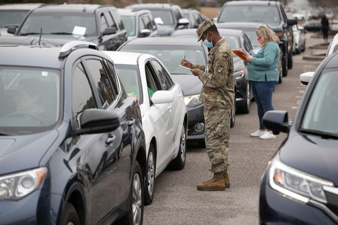 Keith Parham, a contact tracer with the Johnston County Health Department, works to help register the large crowd that arrived at Corinth Holders High School for a mass COVID-19 vaccination clinic on Wednesday, March 17, 2021 in Wendell, N.C.