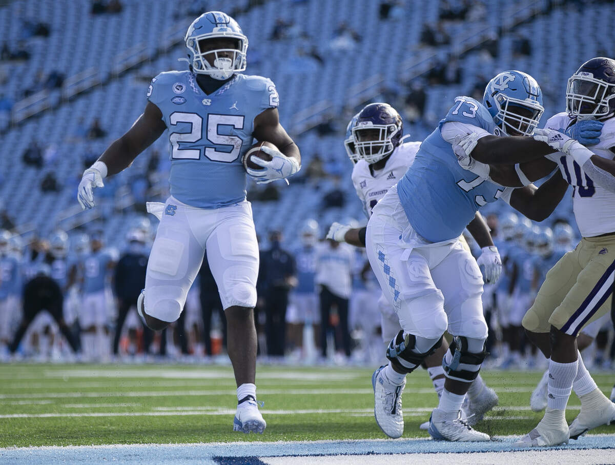 North Carolina’s Javonte Williams (25) scores on a three-day run in the second quarter to give the Tar Heels a 28-3 lead in the second quarter against Western Carolina on Saturday, December 5, 2020 at Kenan Stadium in Chapel Hill, N.C.