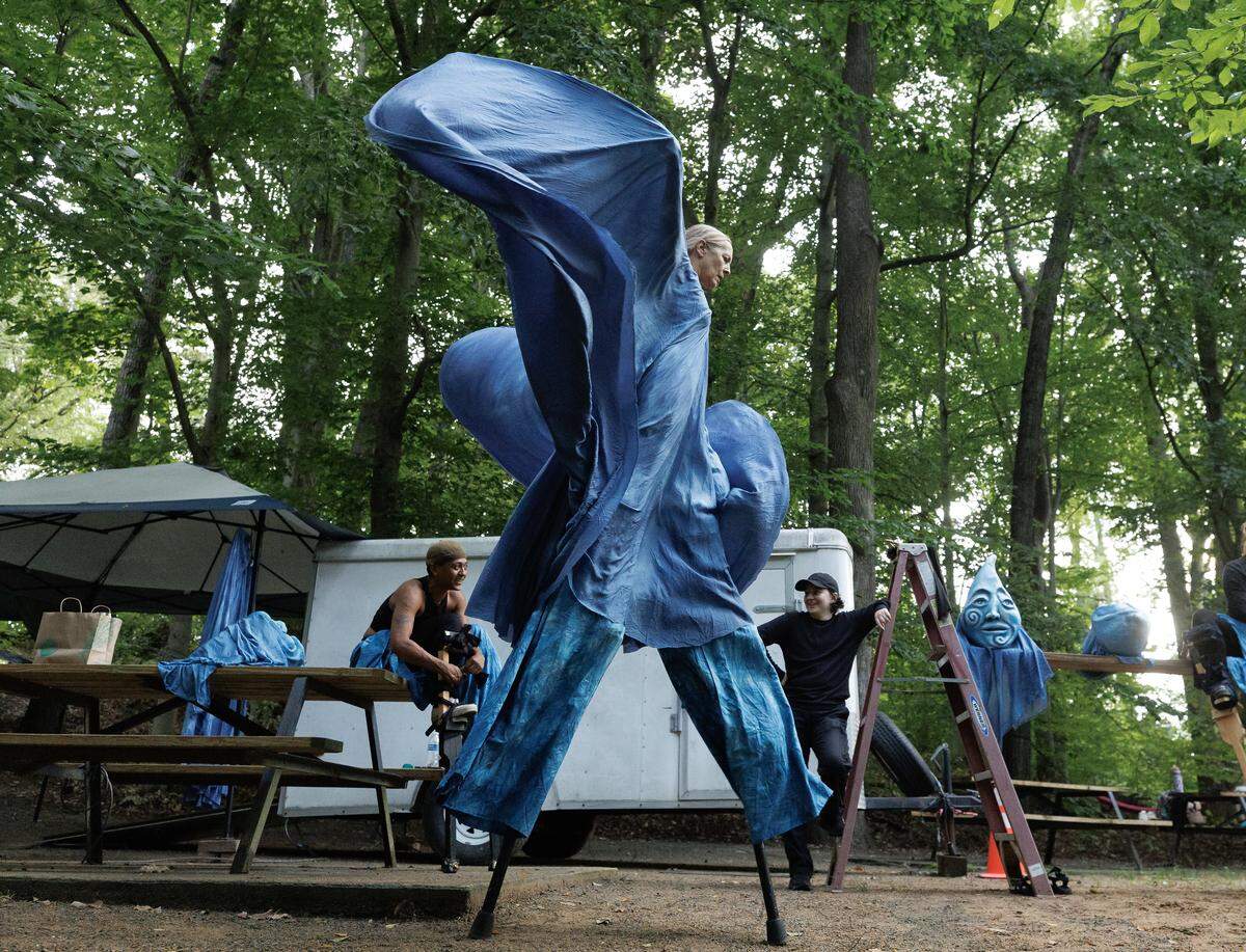 Barb Ford, a puppeteer and assistant stage manager for Paperhand Puppet Intervention, practices walking on stilts while wearing a water being costume during rehearsal for the company’s show, “The Gift,” on Tuesday, Aug. 12, 2025, at the Forest Theatre in Chapel Hill, N.C.
