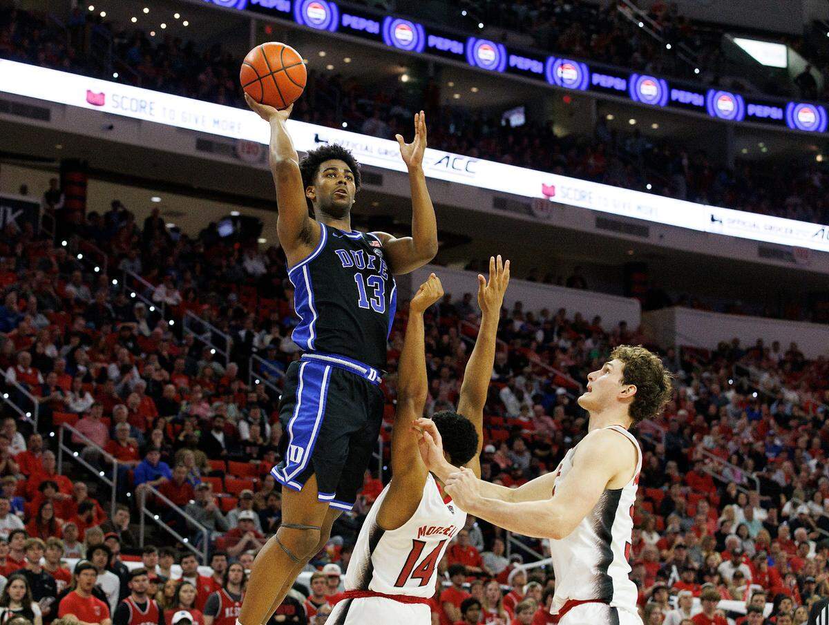 Duke’s Sean Stewart shoots over N.C. State’s Casey Morsell and Ben Middlebrooks during the second half of the Blue Devils’ 79-64 win on Monday, March 4, 2024, at PNC Arena in Raleigh, N.C.