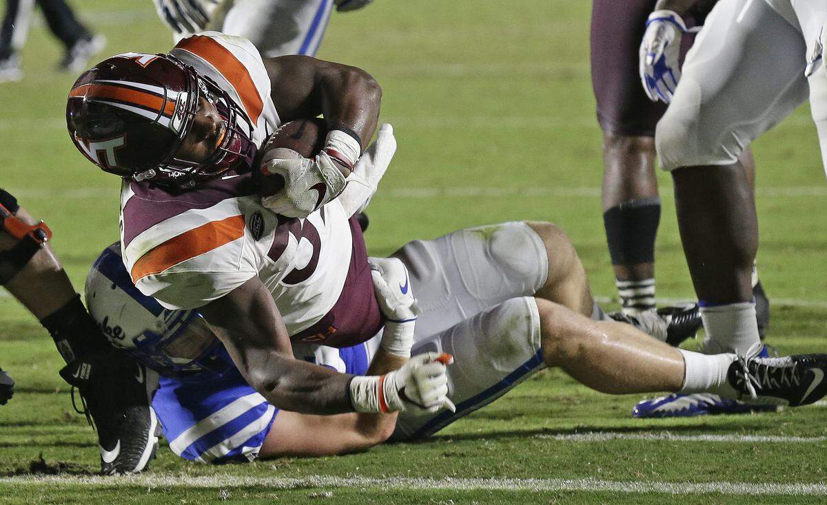 Virginia Tech’s Steven Peoples scores a touchdown while Duke’s Ben Humphreys tackles during the second half of an NCAA college football game in Durham, N.C., Saturday, Sept. 29, 2018. Virginia Tech won 31-14. 