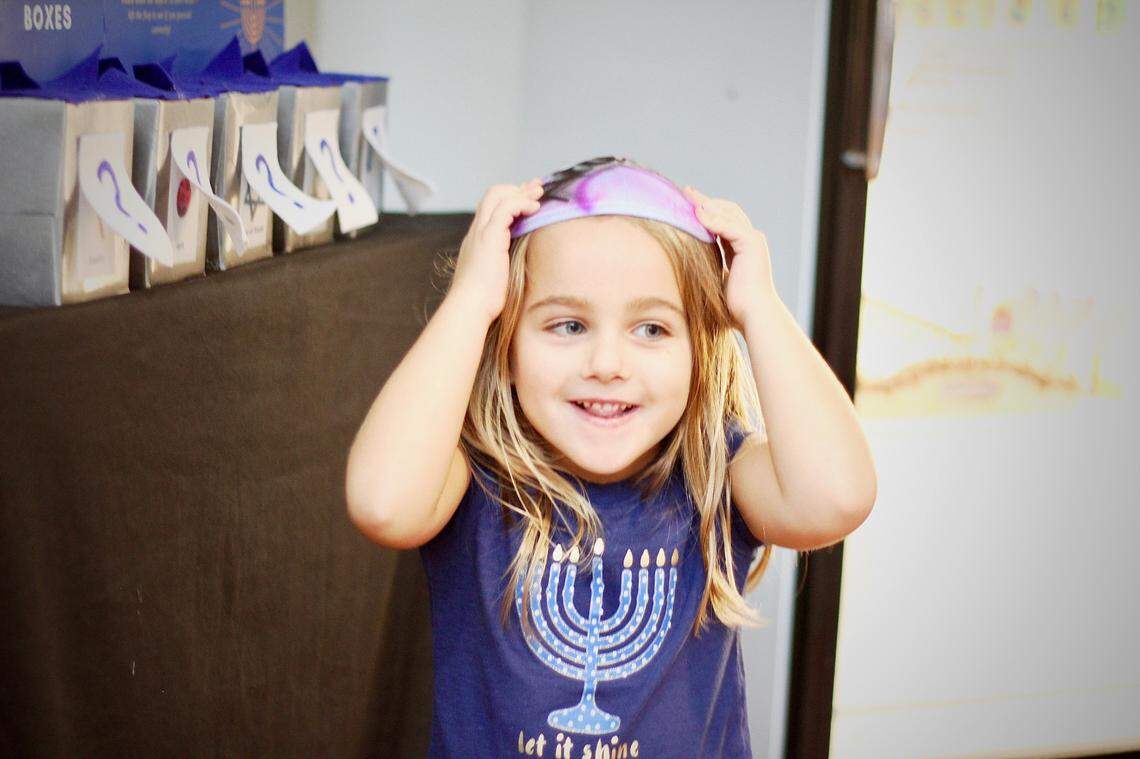 A Durham kindergartener shows off her festive shirt and kippah at Jewish for Good’s 2019 Hanukkah Festival