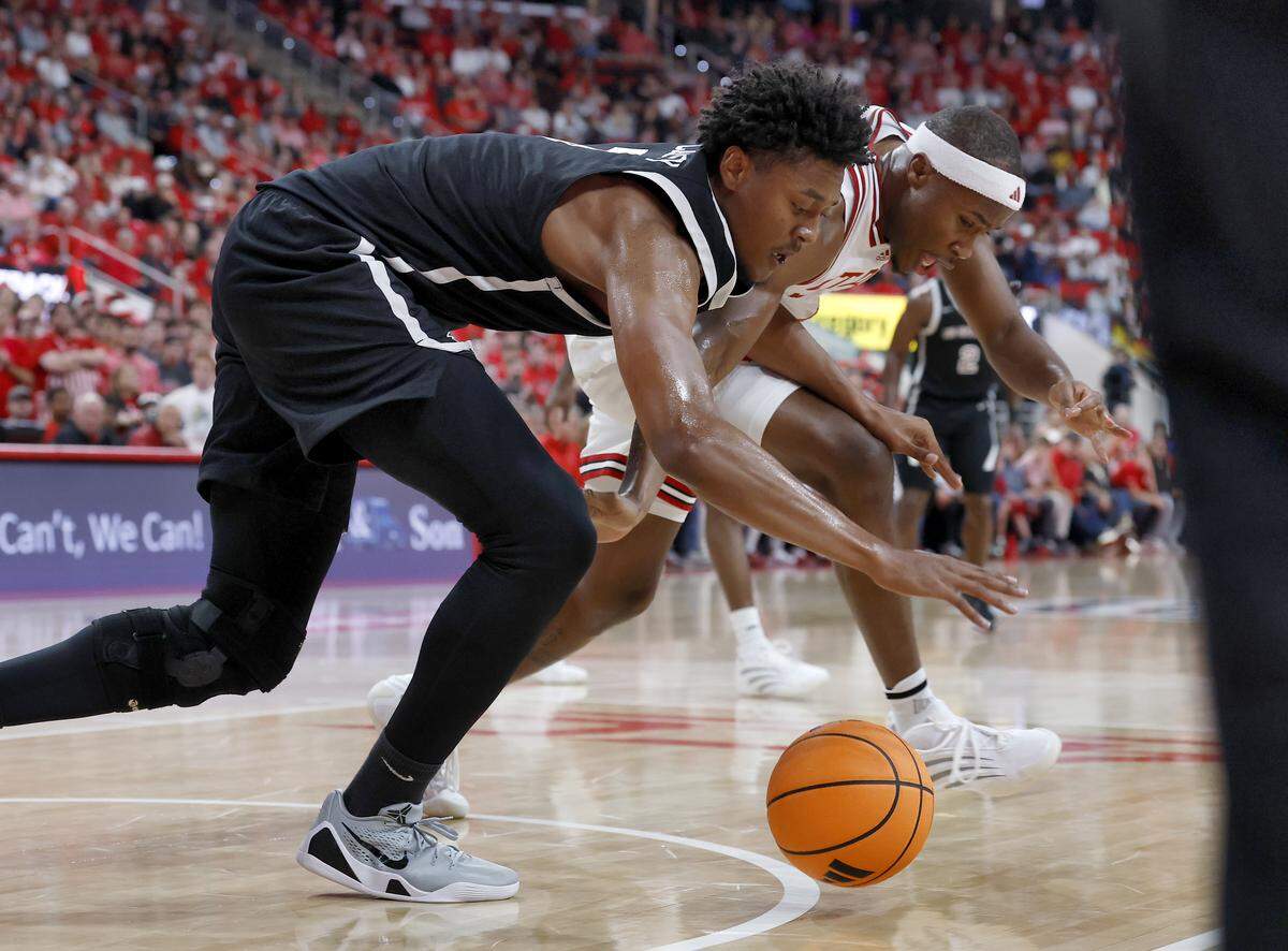 N.C. State’s Tre Holloman and North Carolina Central’s Khouri Carvey lunge for a loose ball during the first half of the Wolfpack’s 114-66 win at Lenovo Center on Monday, Nov. 3, 2025, in Raleigh, N.C.