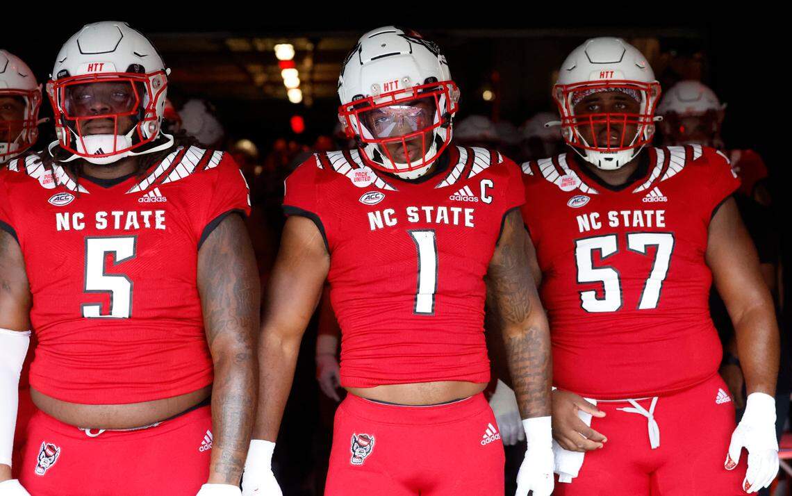 From left, N.C. State’s C.J. Clark (5), Isaiah Moore (1) and Lyndon Cooper (57) prepare to head out onto the field to warmup before N.C. State’s game against Boston College at Carter-Finley Stadium in Raleigh, N.C., Saturday, Nov. 12, 2022.