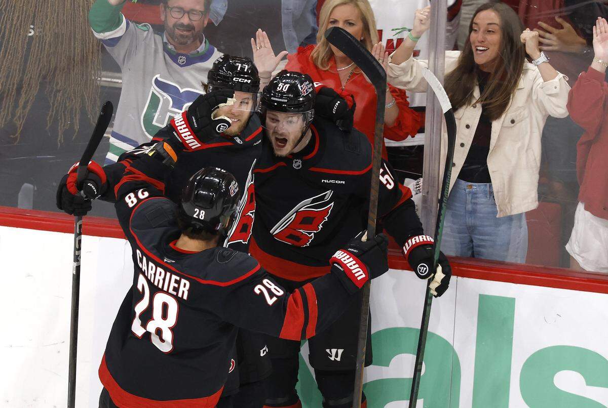 Carolina's William Carrier (28) and Mark Jankowski (77) celebrate with Eric Robinson (50) after Robinson scored in the first period of the Hurricanes’ game against the Canadiens in game five of the Eastern Conference Finals at the Lenovo Center Friday, May 29, 2026.
