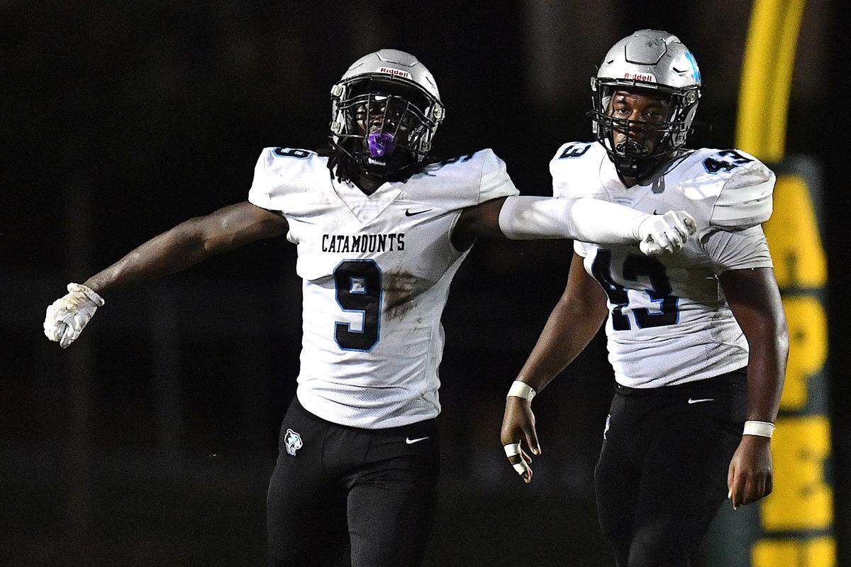 Panther Creek defensive end Lacina Coulibaly (9) celebrates with Kurai Young (43) after a play against Apex during the second half. The Apex Cougars and the Panther Creek Catamounts met in a conference football game in Apex, N.C. on September 20, 2024.
