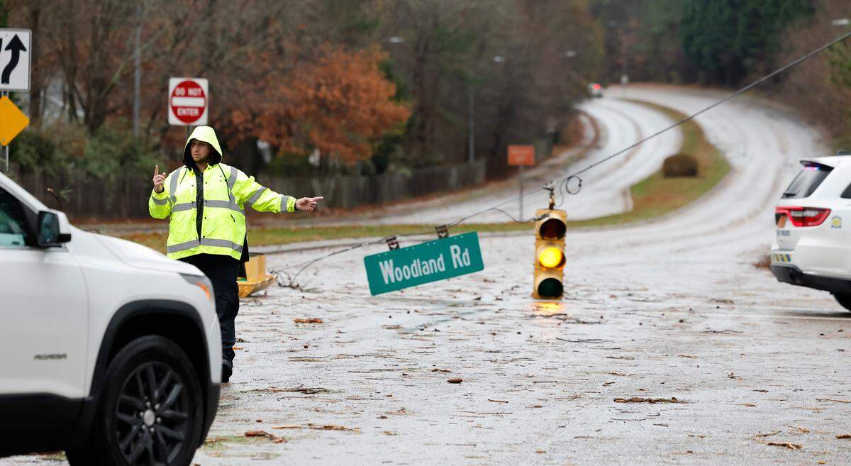 Garner police direct traffic off Timber Drive at Woodland Road after a storm knocked down limbs and traffic lights in Garner, N.C., Sunday, Dec. 10, 2023.