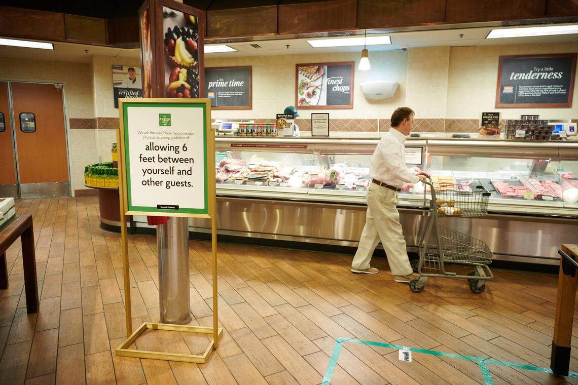Signs at Fresh Market stores remind customers about social distancing practices in an effort to stop the spread of COVID-19 coronavirus.