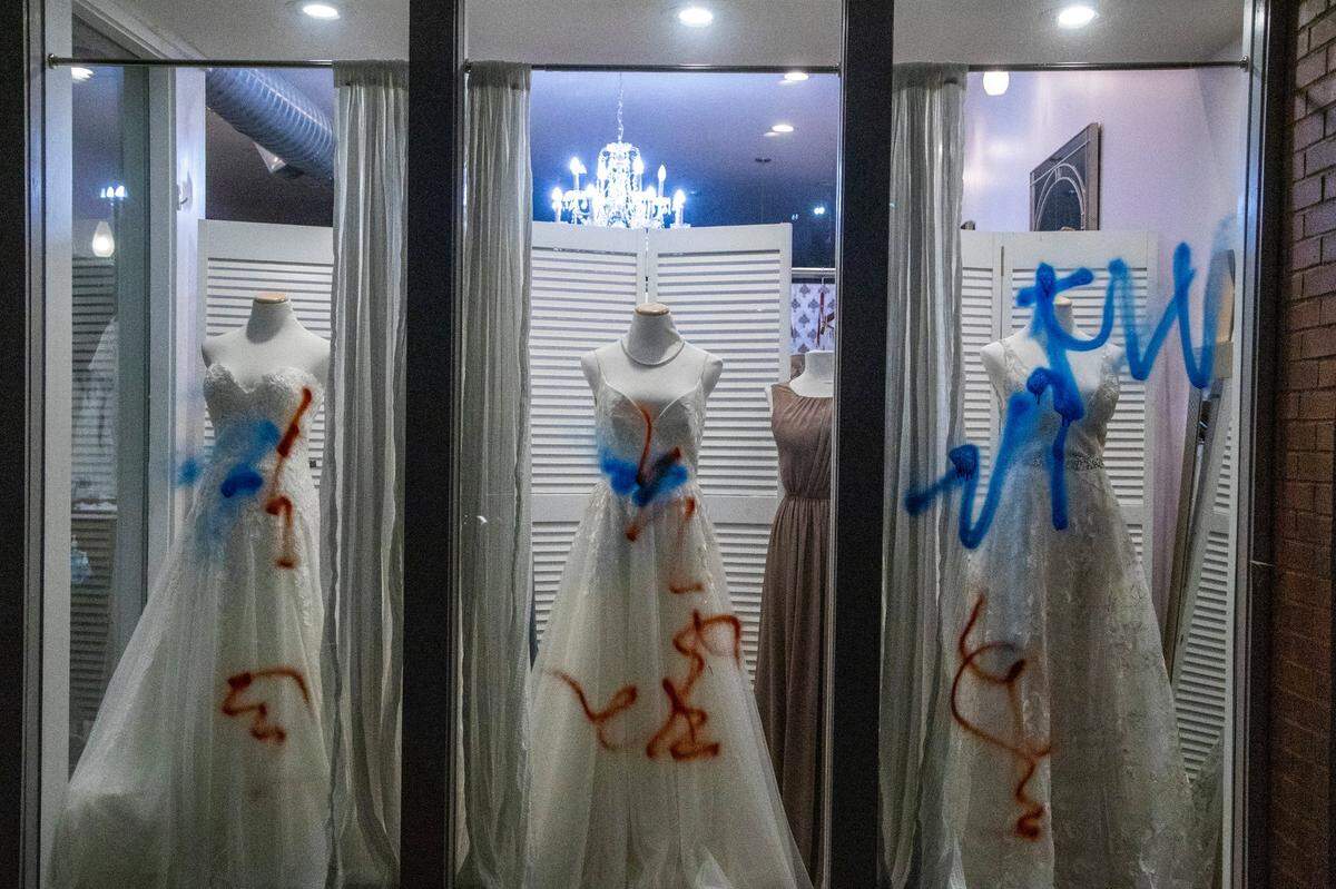 A business is vandalized as demonstrators rallied and marched in downtown Durham in response to recent police killings and violence against transgender people Friday, April 16, 2021.