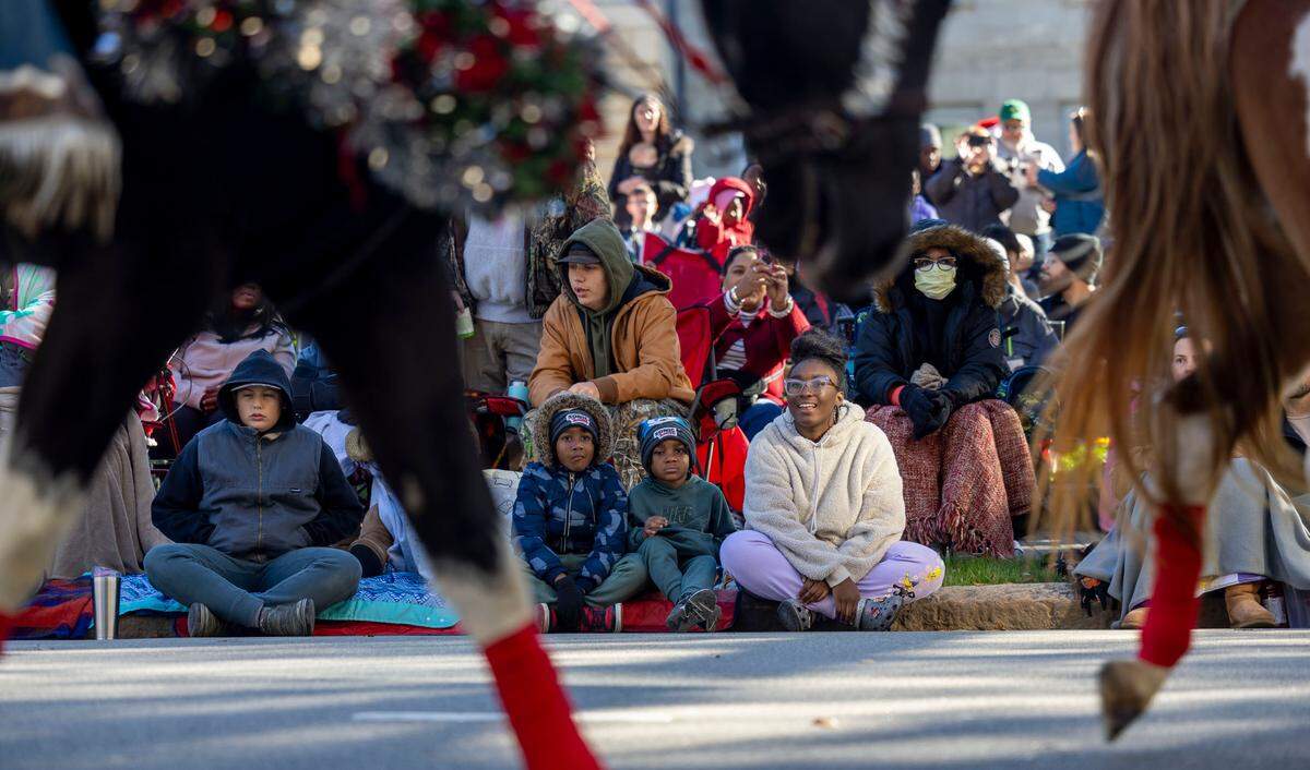 Harmony Garrett of Knightdale, watches horses dressed in holiday attire, during the 80th annual Raleigh Christmas Parade on Saturday, November 23, 2024 in Raleigh, N.C.