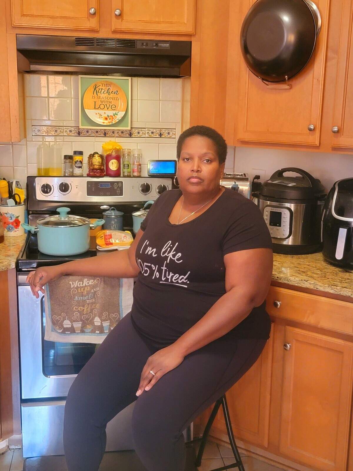 Brooke Keaton of Charlotte perches on the stool in her kitchen that allows her to cook for her husband and daughter.s when she’s not exhausted from the symptoms of long COVID.
