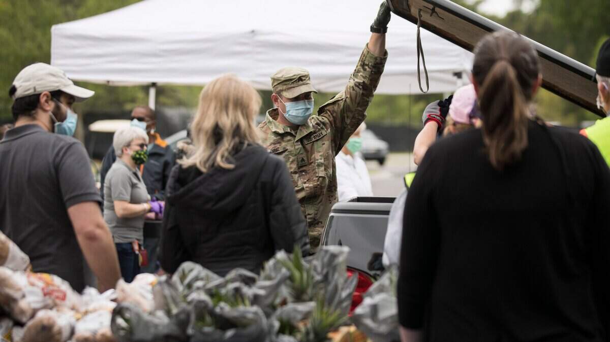 Army National Guard member Randall Rose, middle, closes a truck bed after loading it with food at Cedar Ridge High School in Hillsborough, N.C. on Wednesday, May 13, 2020. The Food Bank of Central and Eastern North Carolina partnered with the Gary Sinise Foundation to donate over 300 boxes of food, produce, and local milk from Maple View Farms to veterans, active duty military members and their spouses.