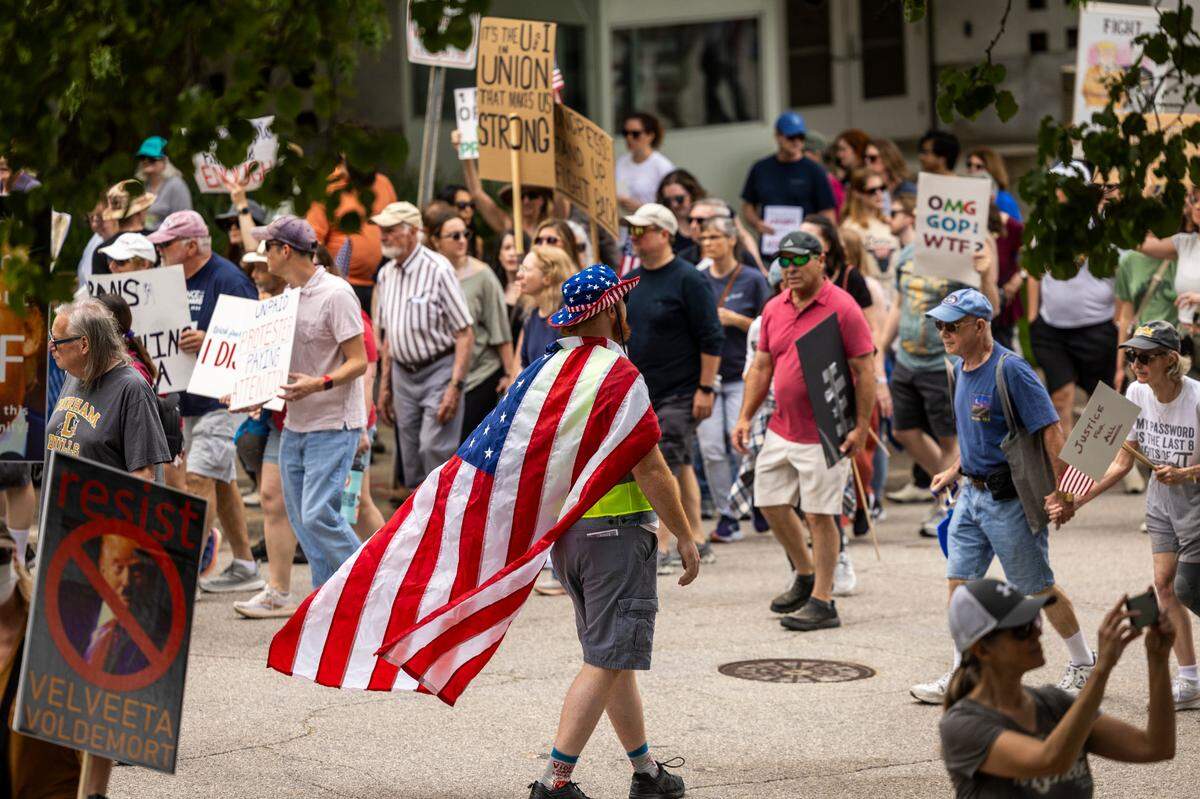More than 1000 demonstrators march around the Legislative Building after rallying on Halifax Mall in Raleigh to protest Trump administration policies on Saturday, April 19, 2025.