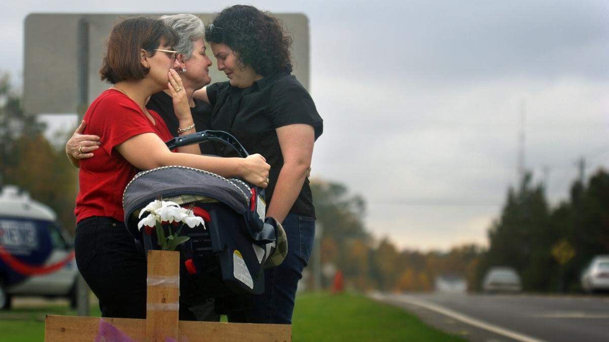 Lauren Murphy, right, is consoled by her mother Renee Murphy, center, and her sister-in-law Heather Murphy at the site of an accident Saturday night, Sept. 3, 2003 that killed Lauren's boyfriend Dennis Bowes and five others who had stopped to help victims of another car accident. Friends said that Dennis had been talking about buying an engagement ring for Lauren in the previous week.