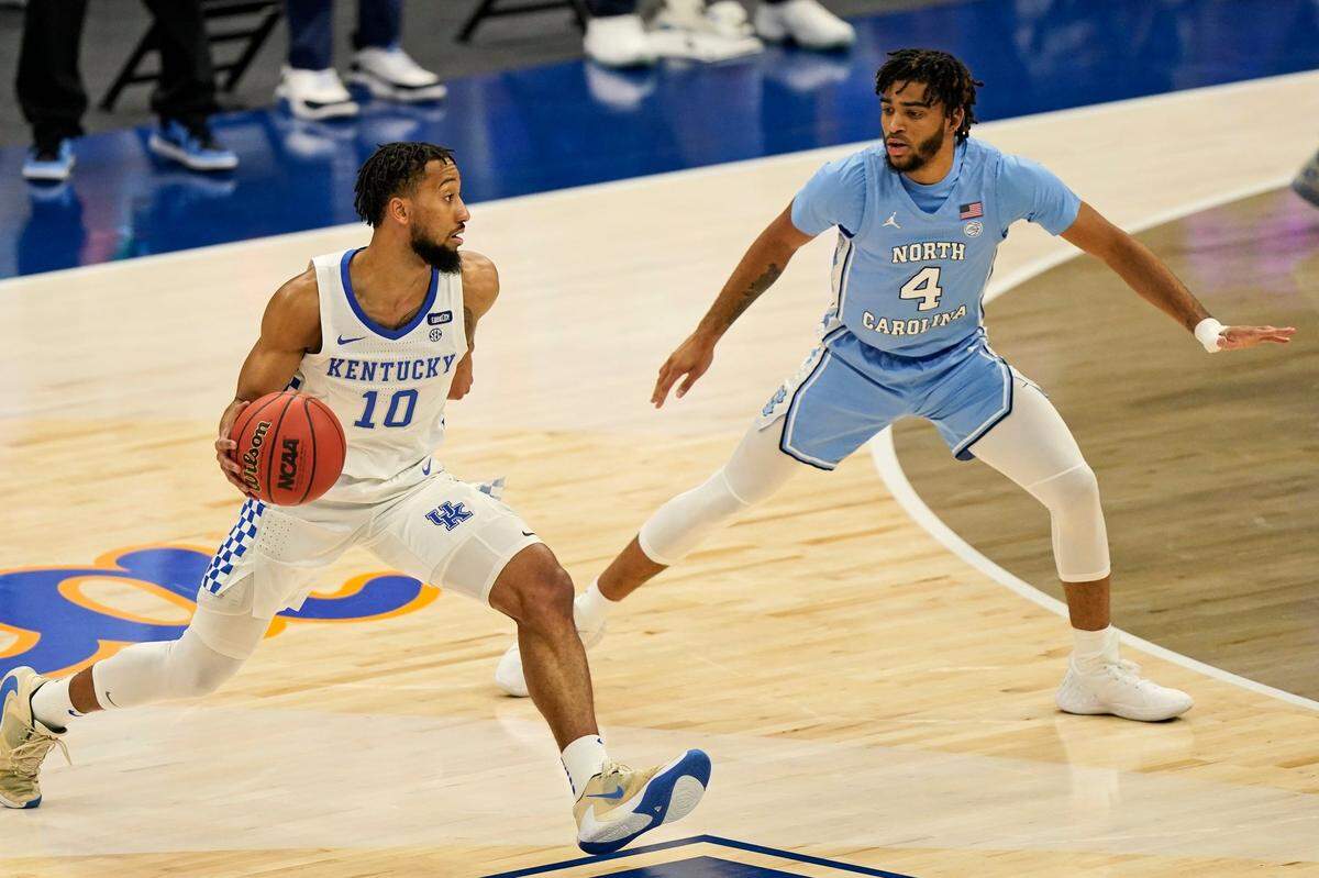 Kentucky’s Davion Mintz (10) drive past North Carolina’s R.J. Davis (4) in the first half of an NCAA college basketball game, Saturday, Dec. 19, 2020, in Cleveland.