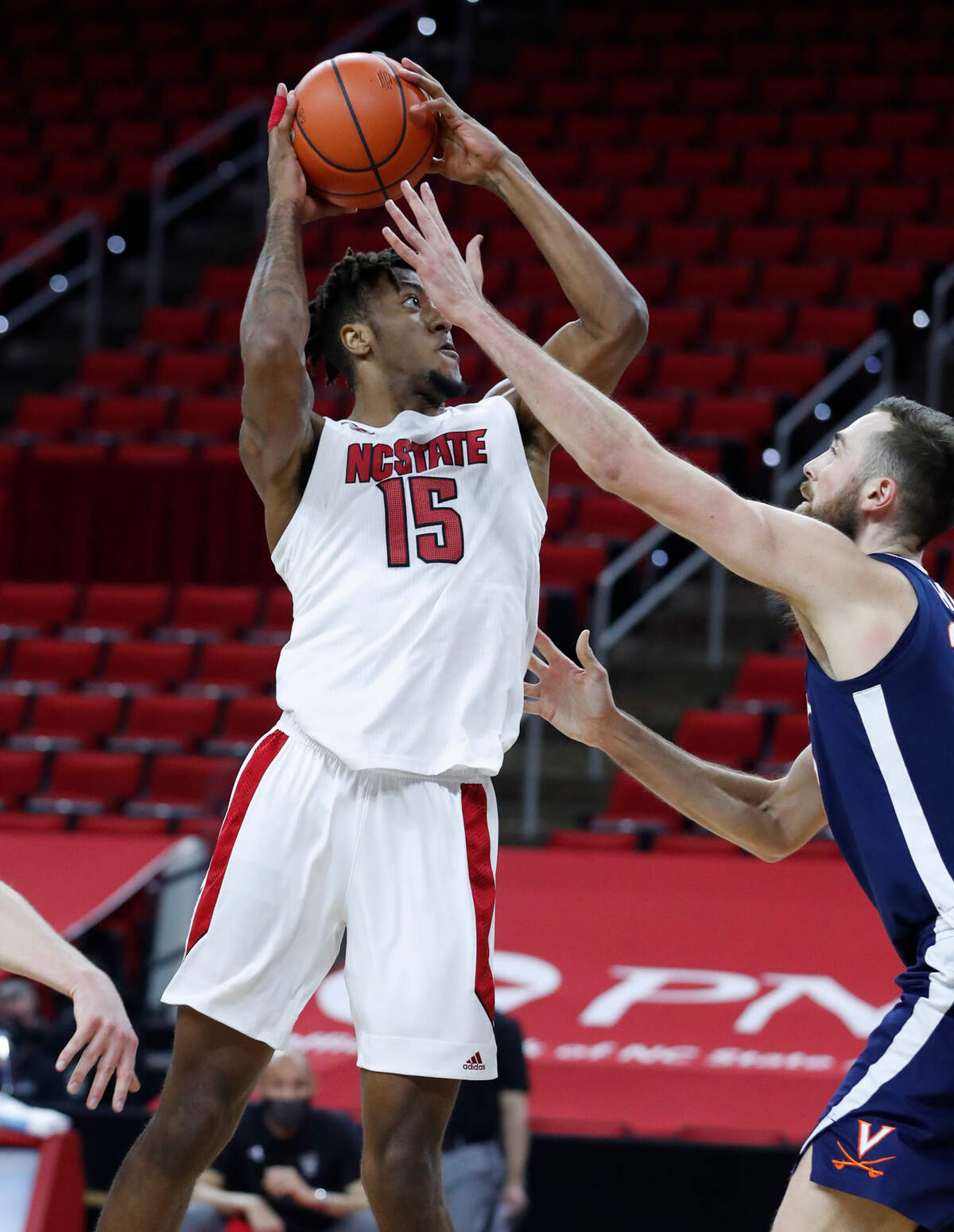 N.C. State’s Manny Bates (15) shoots as Virginia’s Jay Huff (30) defends during the second half of Virginia’s 64-57 victory over N.C. State at PNC Arena in Raleigh, N.C., Wednesday, February 3, 2021.