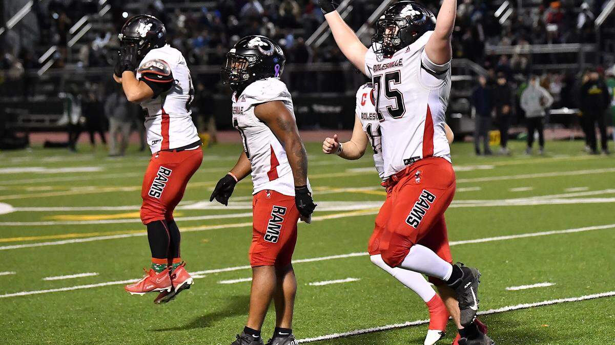 Rolesville’s Devon Thomas (0), Ian Hemilright (75) and teammates celebrate their victory over Cardinal Gibbons clinching the East Regional 4A Championship. The Rolesville Rams and the Cardinal Gibbons Crusaders met in the East Regional Final of the NCHSAA 4A football playoffs in Raleigh, N.C. on December 13, 2024.