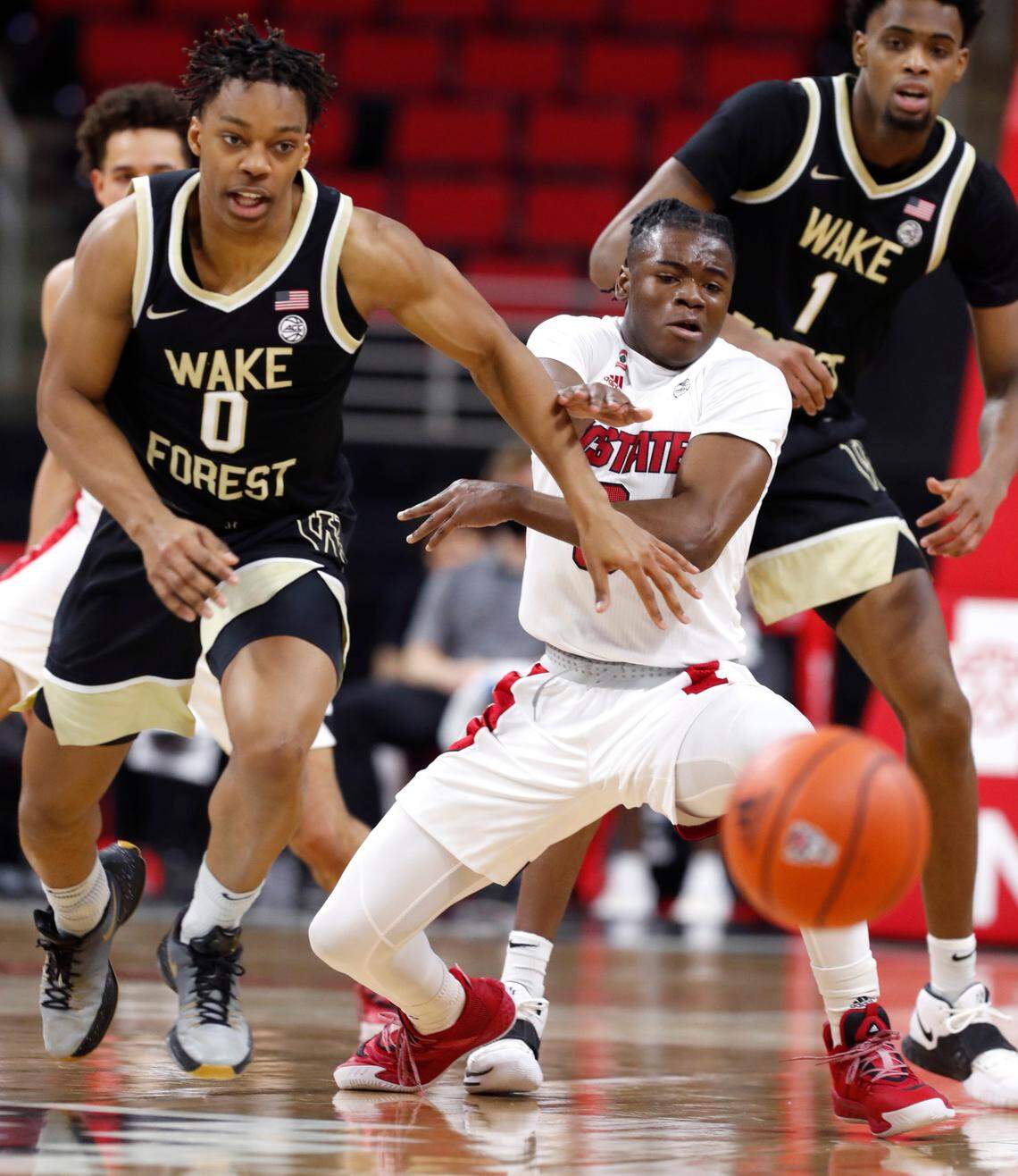 Wake Forest’s Jahcobi Neath (0) and N.C. State’s Cam Hayes (3) go after the loose ball during the first half of N.C. State’s game against Wake Forest at PNC Arena in Raleigh, N.C., Wednesday, January 27, 2021.