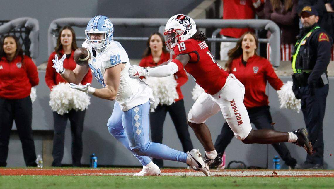 North Carolina tight end John Copenhaver (81) pulls in a 15-yard touchdown reception as N.C. State safety Bishop Fitzgerald (19) defends during the first half of N.C. State’s game against UNC at Carter-Finley Stadium in Raleigh, N.C., Saturday, Nov. 25, 2023.