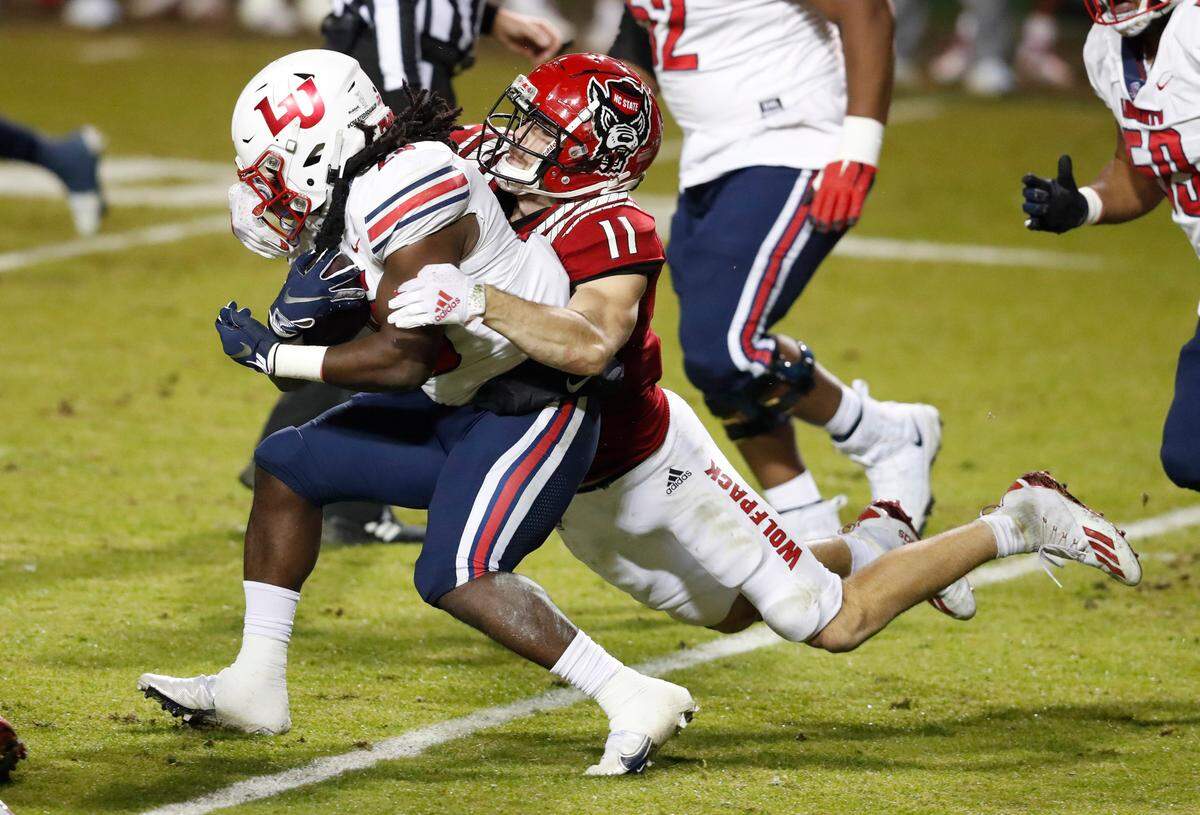 N.C. State linebacker Payton Wilson (11) tackles Liberty running back Peytton Pickett (25) during the first half of N.C. State’s game against Liberty at Carter-Finley Stadium in Raleigh, N.C., Saturday, Nov. 21, 2020.