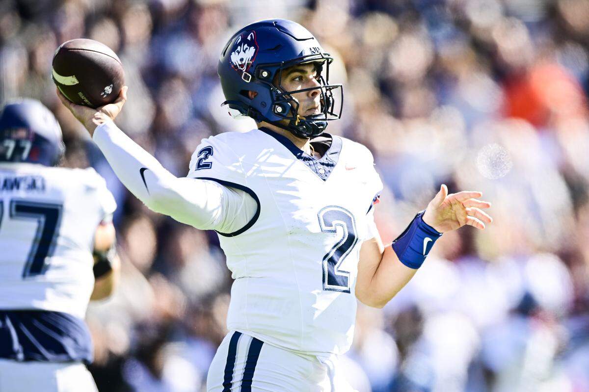 Joe Fagnano of the UConn Huskies looks to make a pass during the first quarter of a game against Boston College Eagles at Alumni Stadium on October 18, 2025 in Chestnut Hill, Massachusetts.