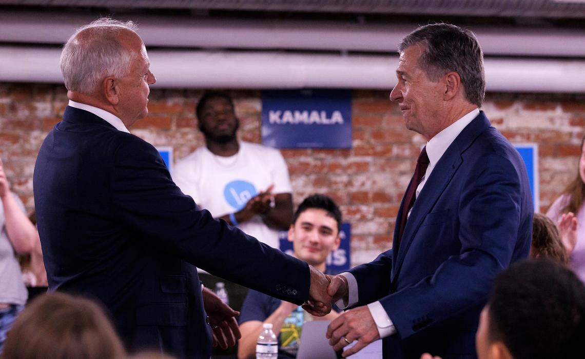 Democratic Vice Presidential nominee and Minnesota Gov. Tim Walz shakes hands with Gov. Roy Cooper during a visit to a campaign office in Raleigh, N.C. on Thursday, Aug. 29, 2024.