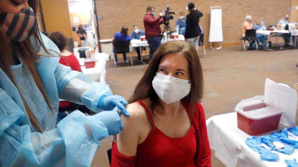 Natalie Macpherson, an English teacher at Sanderson High School, smiles after Crystal Truitt gave her a COVID-19 vaccine shot during a mass vaccine event at Wake County Commons Building in Raleigh, N.C., Wednesday, February 24, 2021. Wednesday was the first day preK-12 public, private and charter schools, as well as childcare workers, became eligible to begin getting shots.